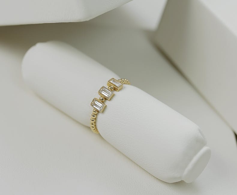Close-up of an elegant gold ring with diamonds, showcased on a white background.